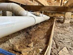 Newly installed PVC drainage pipes under a house foundation, part of Bay Plumbing and Drainage's services in Geelong.