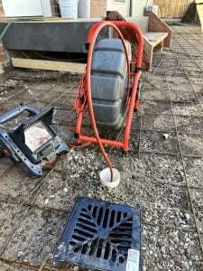 Bay Plumbing and Drainage's industrial drain cleaning machine, connected to a drainpipe on a residential call out in Geelong.