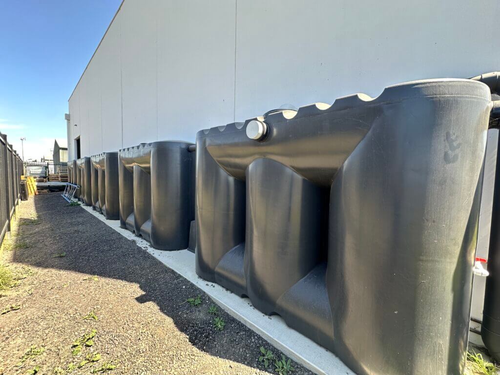 Large poly rainwater tanks installed for commercial water storage.