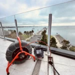 Drain inspection equipment set up on a rooftop to check blocked drains in a strata complex.