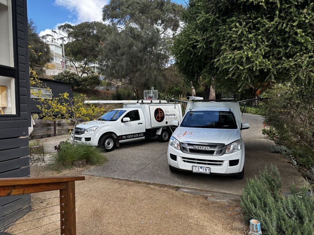 2 Bay Plumbing & Drainage service vehicles parked in the driveway of a Highton home