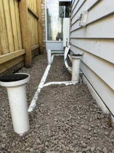 a white pipes and gravel next to a house