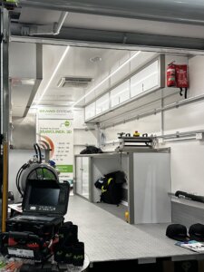 Relining equipment truck with the back door open, showing the work space for reliing drainage  