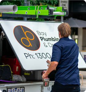 Bay Plumbing & Drainage service vehicle at the rear canopy with a Local Geelong Plumber collecting tools for a job