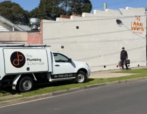 A Bay Plumbing and Drainage plumber walks back to the work ute carrying his tool case.